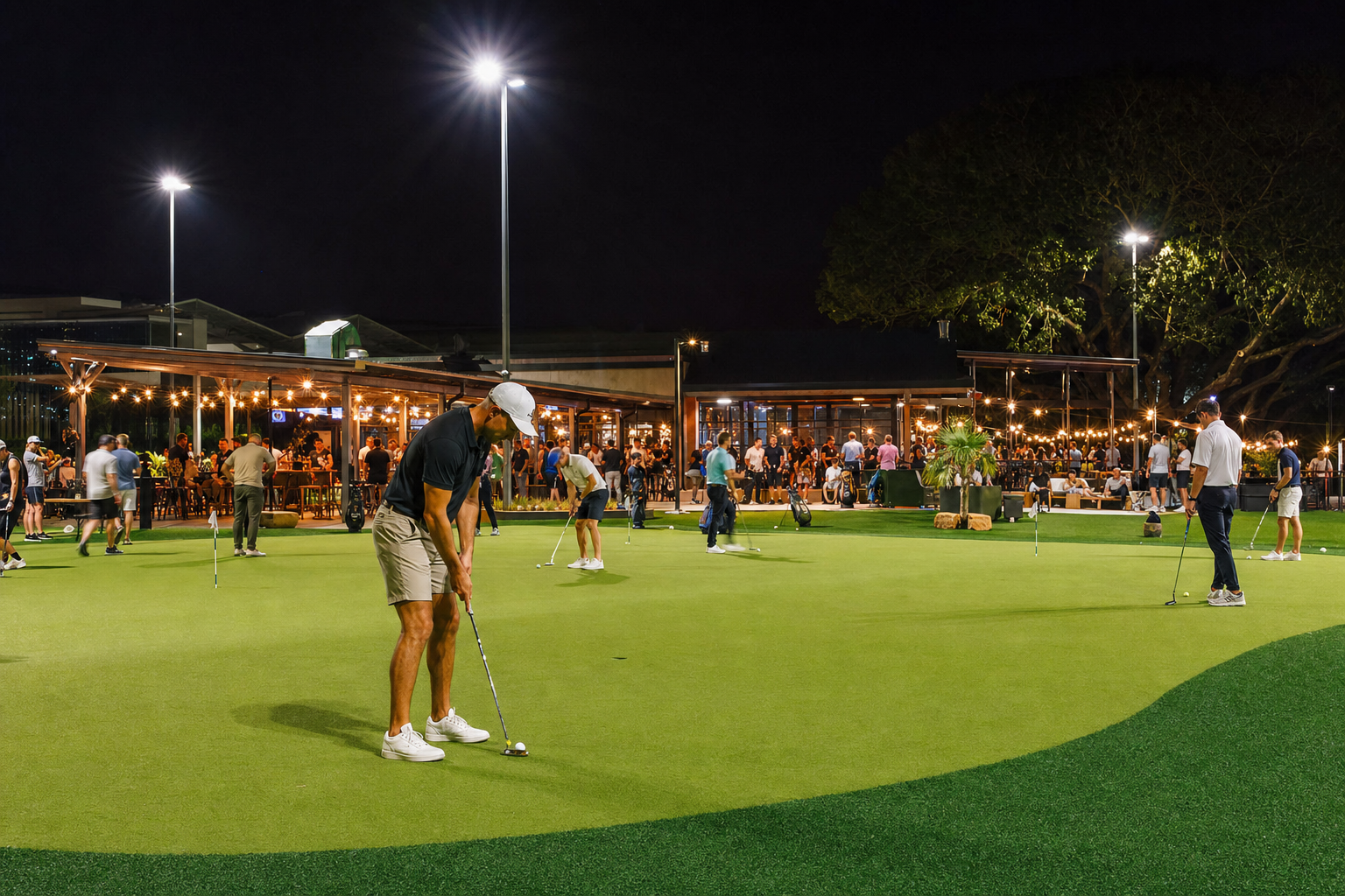 The practice green at The Yard under floodlights